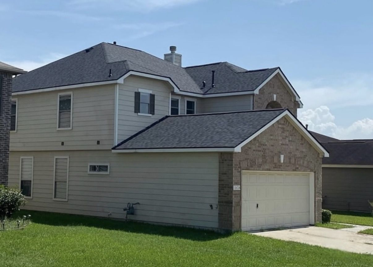 Completed charcoal shingle roof replacement on a Houston two-story home